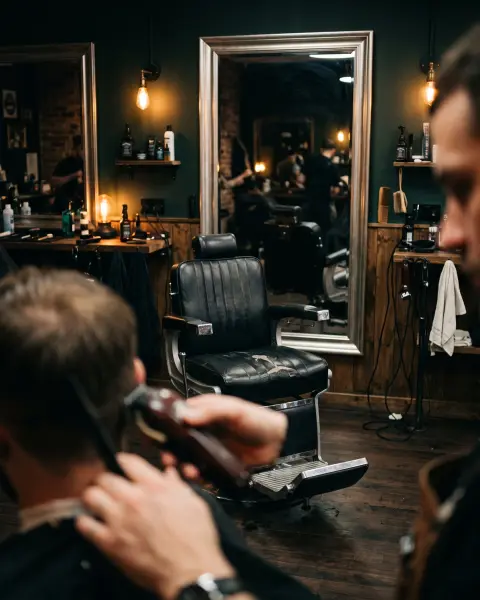 Zwarte barbiersstoel in een donkere barbershop met warme lampen